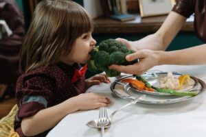 Kind beißt in Brokkoli