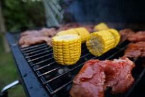 Fleisch und Mais auf dem Grill.